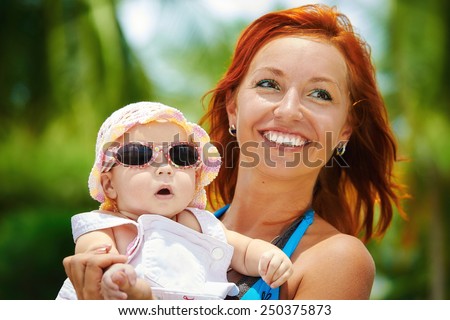 Beautiful Mother And Baby outdoors. Beauty Mum and her Child playing in outdoor together. Outdoor Portrait of happy family.
