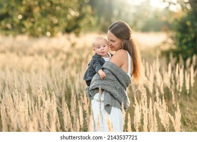 Beautiful mother with a child in the meadow. Happy mother and child are hugging. Motherhood. Tenderness of mother and child. Happy childhood. Mother's love. Love between mother and child. Mom with a c - Shutterstock ID 2143537721