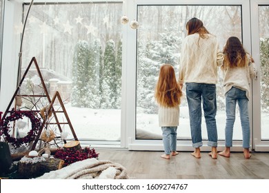 Beautiful Mother With Children. Family At Home. People Standing Near Winter Windows