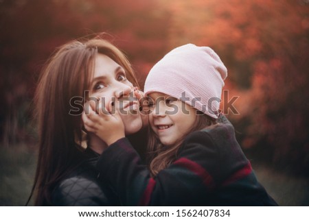 Beautiful mother and daughter hugging in autumn forest. Happy lifestyle family photo.