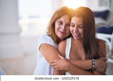 Beautiful mother and daugther hugging at terrace with happy face - Powered by Shutterstock