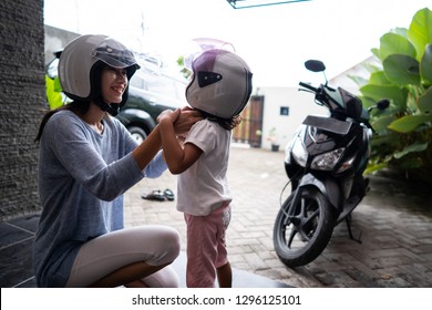 beautiful mother help her child to put on a helmet. safety first before riding a motorbike - Powered by Shutterstock