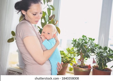 Beautiful Mother Holding In Arms Her Little Cute Newborn Infant Son. Baby Facial Expressions. Family At Home By The Window. Healthy Child, Concept Of Hospital And Happy Motherhood. Nursery.