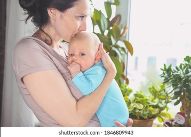 Beautiful Mother Holding In Arms Her Little Cute Newborn Infant Son. Baby Facial Expressions. Family At Home By The Window. Healthy Child, Concept Of Hospital And Happy Motherhood. Nursery.