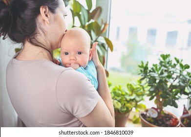 Beautiful Mother Holding In Arms Her Little Cute Newborn Infant Son. Baby Facial Expressions. Family At Home By The Window. Healthy Child, Concept Of Hospital And Happy Motherhood. Nursery.