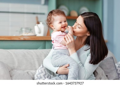 Beautiful mother kisses a happy smiling baby. A happy family