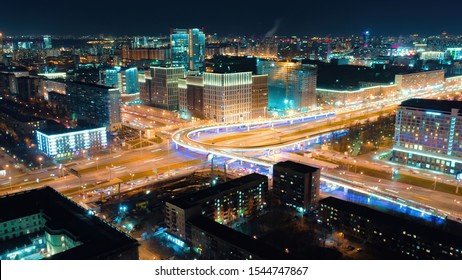 Beautiful Motion Of The Big Road Junction On The Night, View From Above. Aerial Shot Of Busy Crossroad In Moscow Center With A Lot Of Traffic And Glittering City Lights.