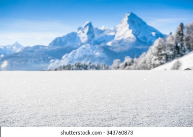Beautiful mountain landscape in the Bavarian Alps with snow bank at front and blurry Watzmann massif in the background at sunrise, Nationalpark Berchtesgadener Land, Bavaria, Germany