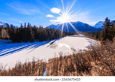 A beautiful mountain range is in the background with a large body of water in the foreground. The sun is shining brightly, creating a warm and inviting atmosphere