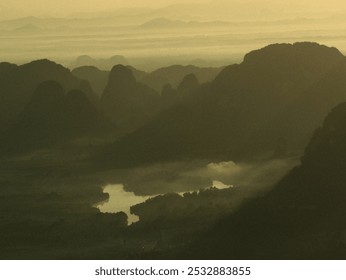 A beautiful mountain range with a river running through it. The mountains are covered in lush green trees, and the river is calm and clear. The sky is a mix of orange and pink hues, creating a serene - Powered by Shutterstock