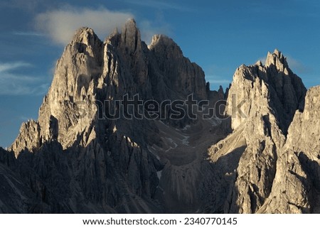 Beautiful mountain rocky peaks lit by beautiful sun and blue sky. Dolomites, Italy
