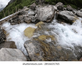 A beautiful mountain stream rushes over smooth rocks.