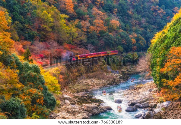日本京陽嵐山の嵐山の川にある嵯峨野景観の鉄道や橋や舟の上の浪漫な列車が乗る秋の美しい山景色 の写真素材 今すぐ編集