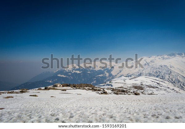 Beautiful mountains and clear blue sky\
viewed from Apharwat of Gulmarg on a sunny spring\
day