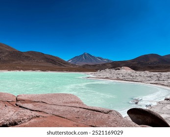 Beautiful mountains landscape with volcano and green lagoon - Piedras Rojas (Red Rocks), Atacama Desert, Chile