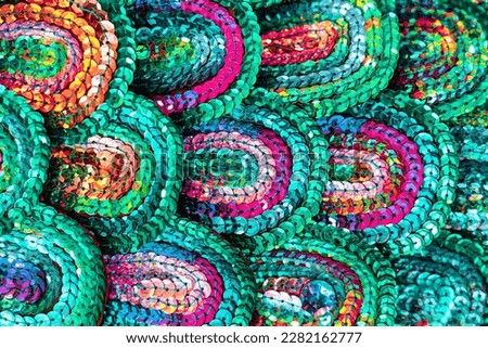 Beautiful multi-colored sequins shimmering in the light in the form of a peacock tail. Abstract background for design.