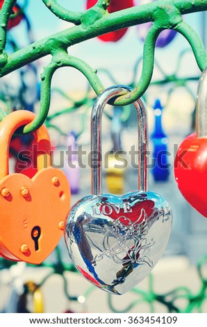 Beautiful multicolored wedding locks on the iron tree of love. Concept of love, loyalty, happiness. Wedding, Valentine's Day, celebration. Warm vintage tinting.