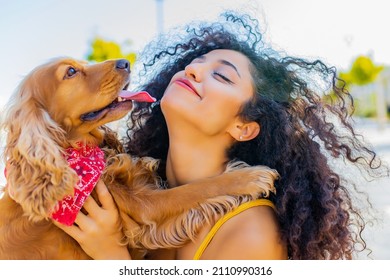 beautiful multicultural woman with make up and curly hair style spending happy times with her cite gold american cocker dog at sunny day in the street