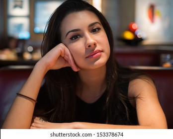 Beautiful multicultural young woman portrait in a restaurant setting.