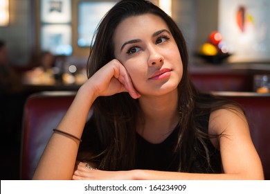 Beautiful multicultural young woman portrait in a restaurant setting.