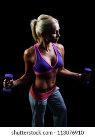 Beautiful muscular woman exercise on a black background