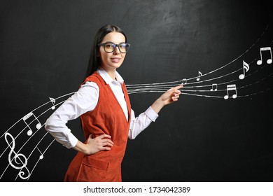 Beautiful Music Teacher Near Blackboard In Classroom