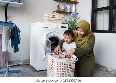 beautiful muslim asian woman doing laundry with her son together