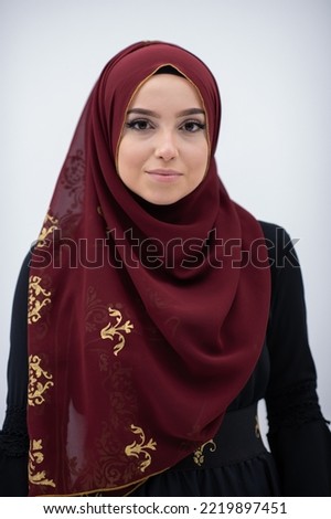 beautiful muslim woman in fashinable dress with hijab isolated on modern cyan background representing concept of modern islam and ramadan kareem