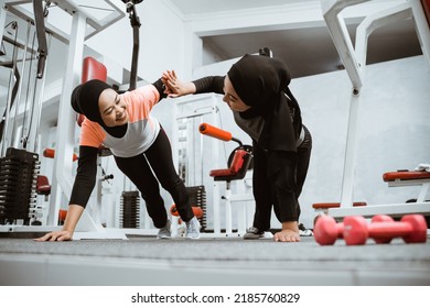 Beautiful Muslim Woman With Hijab Push Up And High Five Workout Together With Partner At The Gym