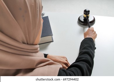 Beautiful Muslim Woman Judge Wear Hijab Striking The Gavel On A Desk. Justice And Law Concept