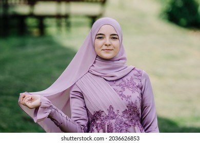 Beautiful Muslim woman playing with her scarf in nature. Modern, Stylish, and Happy Muslim Woman Wearing a Headscarf. 