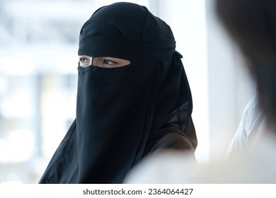 Beautiful Muslim woman wearing the traditional black cloth of the Niqab with her face hidden