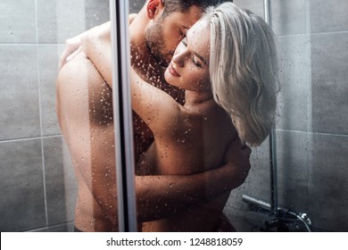 beautiful naked heterosexual couple hugging and taking shower together