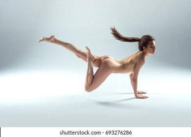 Beautiful Naked Woman Levitating Isolated On The Gray Background