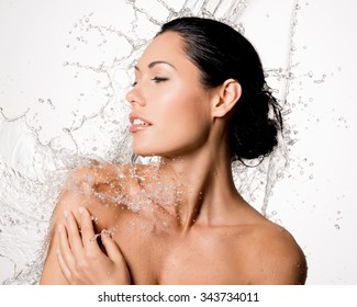 Beautiful naked woman with wet body and splashes of water