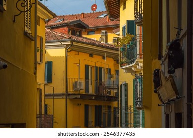 Beautiful narrow alley with vibrant yellow buildings and balconies in a European street. Perfect example of urban architecture. - Powered by Shutterstock