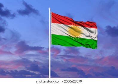 Beautiful national state flag of Kurdistan fluttering at sky background