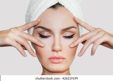 Beautiful natural girl woman after cosmetic procedures ,face-lift , facial massage , visit a beautician , massage lines. Beautiful female with a towel on his head. 
Spa treatments
