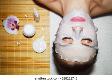 Beautiful natural girl woman in the spa salon, It makes a face mask, facial rejuvenation procedure, spa treatments. Visit a beautician, massage lines. Cosmetology.