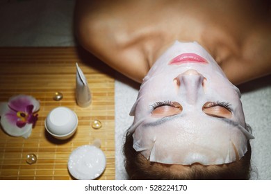 Beautiful natural girl woman in the spa salon, It makes a face mask, facial rejuvenation procedure, spa treatments. Visit a beautician, massage lines. Cosmetology.

