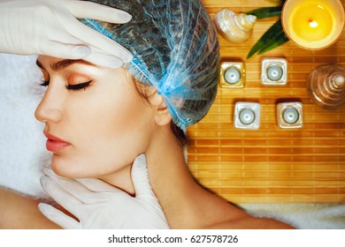 Beautiful natural girl woman in the spa salon, It makes a facial rejuvenation procedure, spa treatments. Visit a beautician, massage lines. Cosmetology. Problem of second chin, double chin
