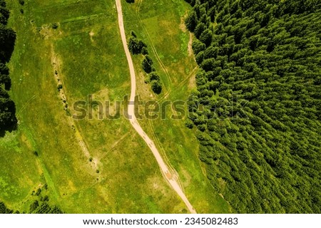 Similar – Image, Stock Photo Textured aerial view of farmland showing geometric patterns of plowed fields in green, yellow, and brown tones