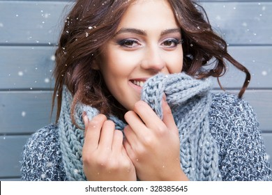 Beautiful Natural Looking Young Smiling Brunette Woman, Wearing Knitted Scarf, Covered With Snow Flakes. Snowing Winter Beauty Concept.