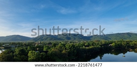 The beautiful natural scenery of lakes, trees, mountains, clouds and sky is a summer travel in Asia. with a landscape and a peaceful and shady environment