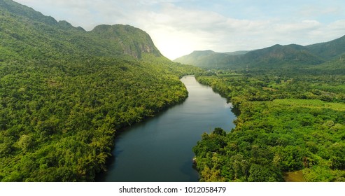 Beautiful natural scenery of river in southeast Asia tropical green forest  with mountains in background, aerial view drone shot - Shutterstock ID 1012058479