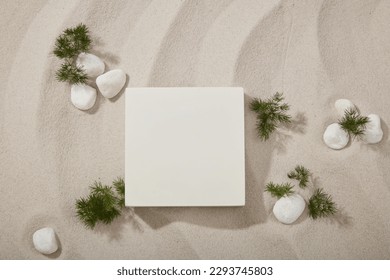 Beautiful natural scenery of the sand with green leaves and white gravels. Empty square podium for product displayed. Stage showcase on minimal podium
