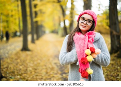 Beautiful natural young smiling brunette woman wearing knitted sweater, gloves, scarf and hat.