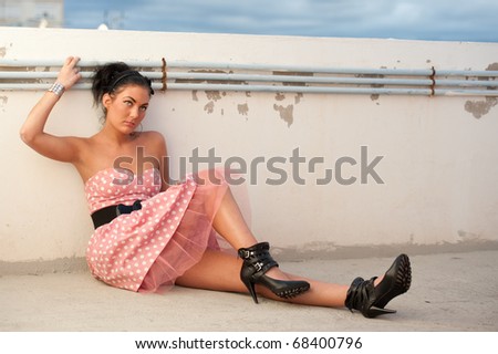 Beautiful and natural young woman wearing a modern pink dress with accessory like belt and headband.