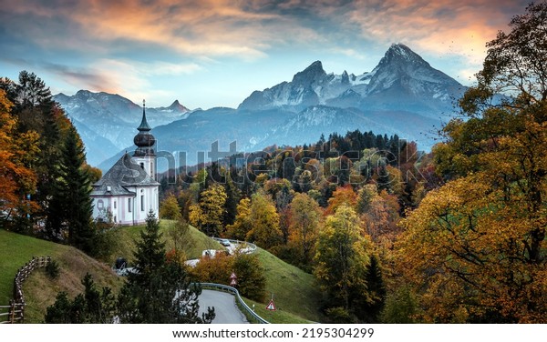 Beautiful nature landscape mural. Incredible autumn scenery. View on Alpine highlands with Watzmann mountduring sunset. Famous Maria Gern Church. Berchtesgaden Bavaria Alps Germany.