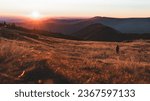 Beautiful nature sunset over horizon on peaks of mountain Krkonose. Woman stands in background, sunrise, Europe, Czech Republic, mountains, hills, wide landcape